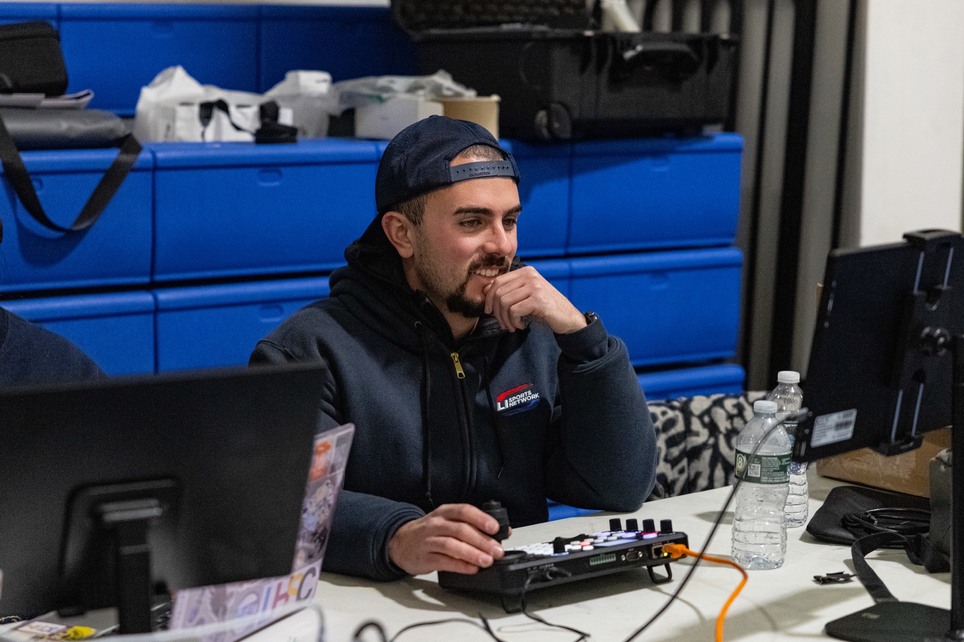 An adult LI Sports Network producer at a live production desk